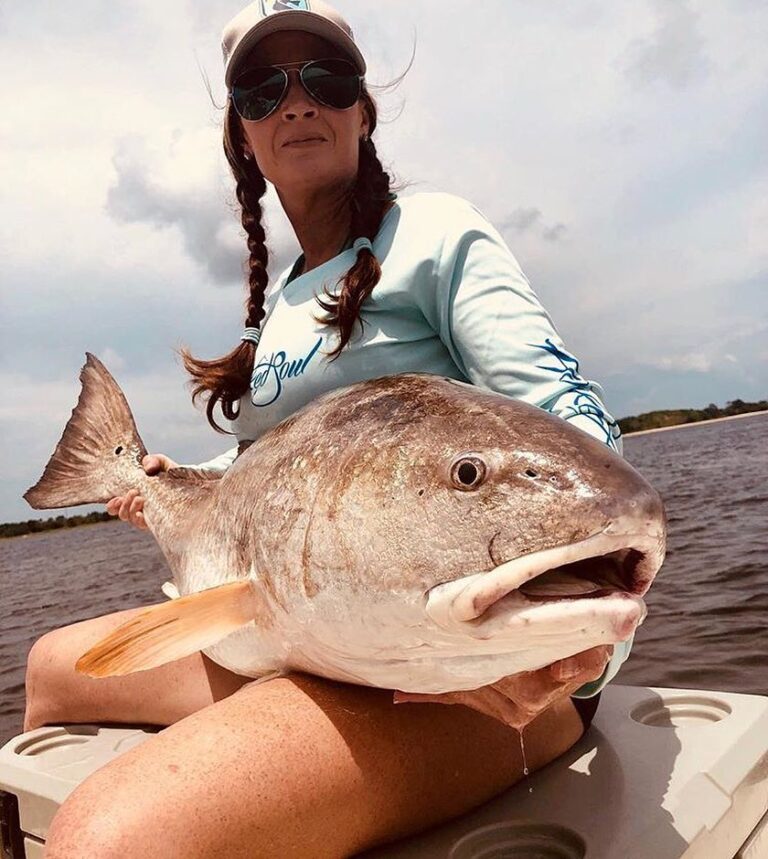 @lauraloves2fish holding a beast bull redfish